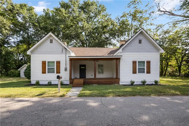 White siding exterior with a covered front porch featuring wood support columns
