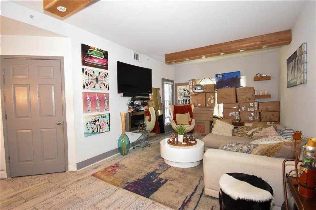 Living room featuring beamed ceiling and wood finished floors