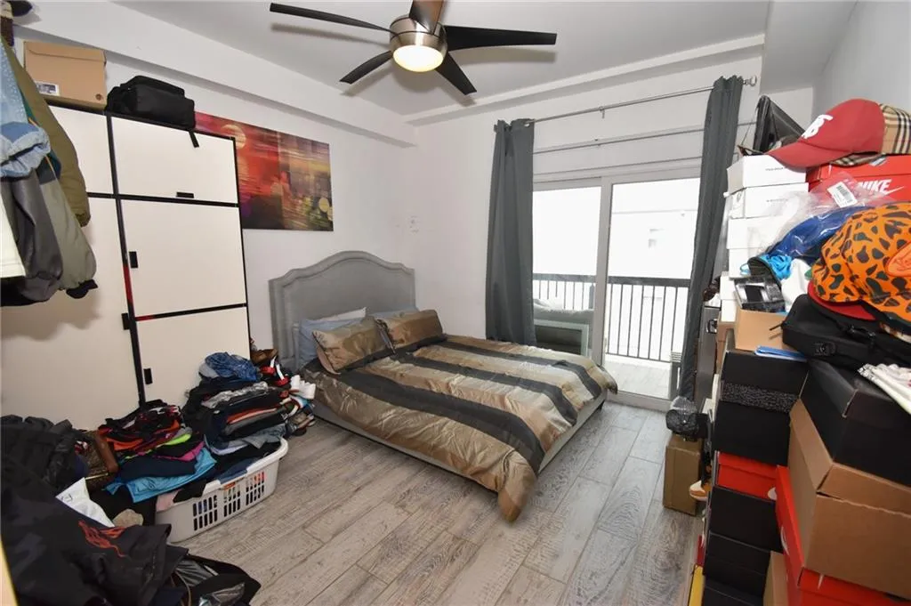 Bedroom featuring wood finished floors, a ceiling fan, and access to outside