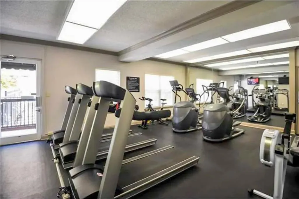 Workout area featuring a textured ceiling and beamed ceiling