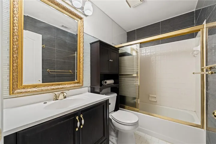 Bathroom vanity with a white countertop and dark wood-finish cabinetry