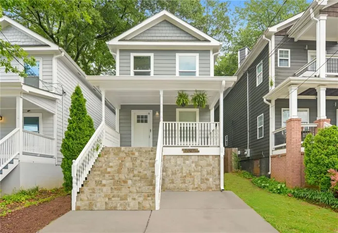 Two-story residence featuring grey horizontal siding and shake shingles on the upper gable