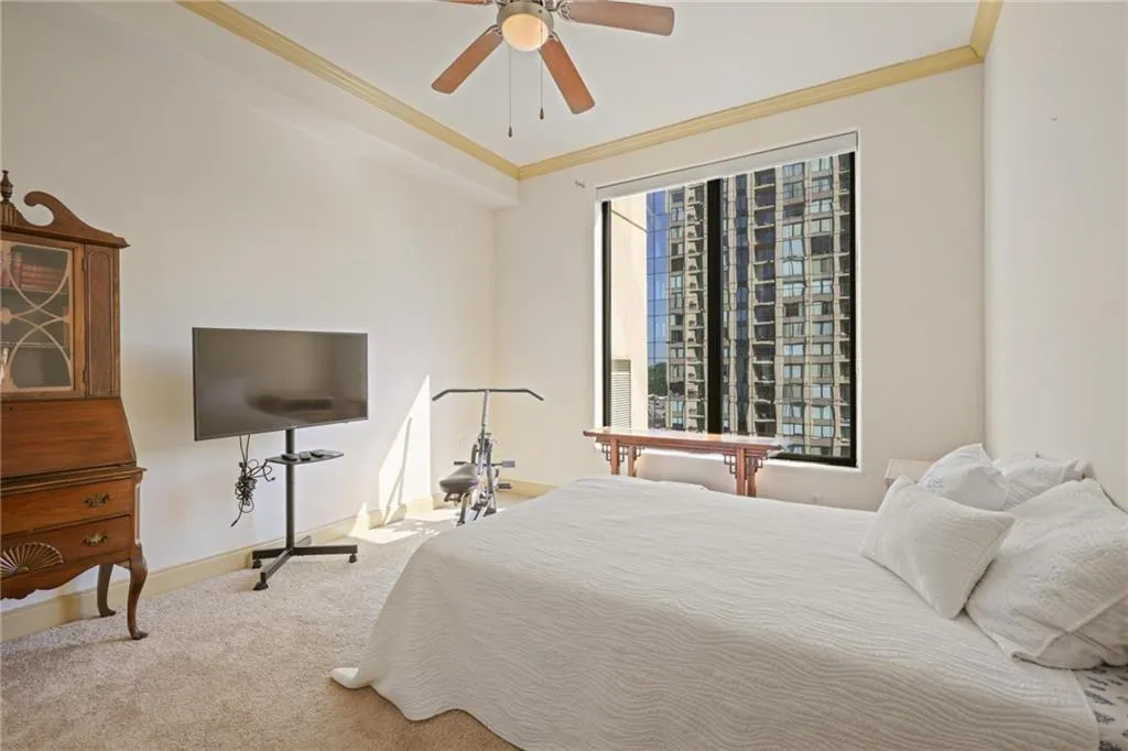Bedroom with crown molding, carpet flooring, and a ceiling fan