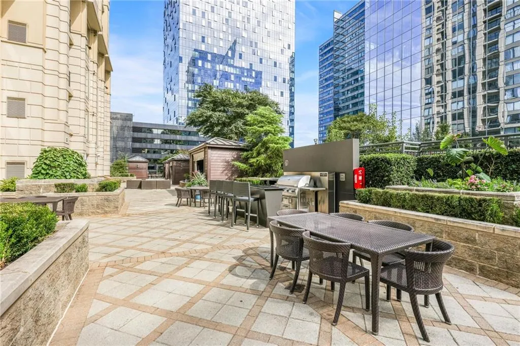 View of patio / terrace with outdoor dining space, a city view, and a grill