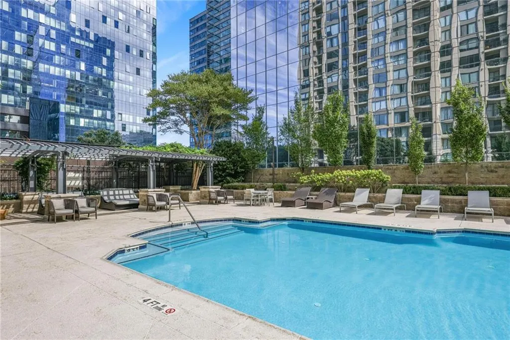 Community pool featuring a patio area, a pergola, and a view of city