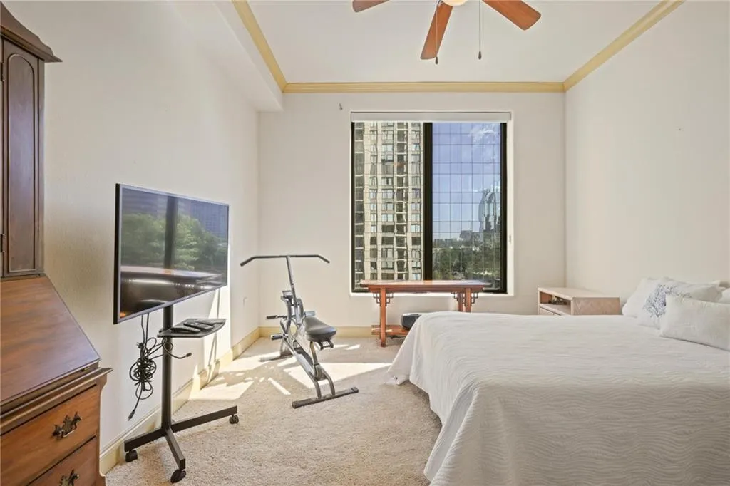 Bedroom featuring carpet, ceiling fan, and crown molding