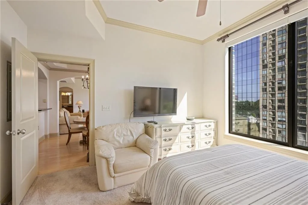 Bedroom with crown molding, arched walkways, carpet floors, a ceiling fan, and wood finished floors