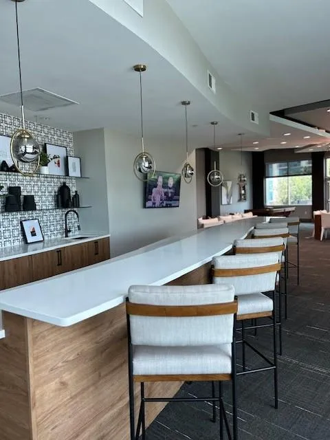 Community bar area featuring decorative light fixtures and backsplash