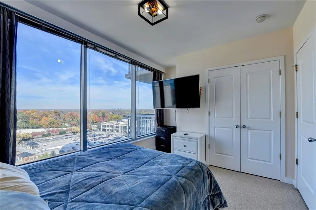 Bedroom with a closet, light carpet, and multiple windows