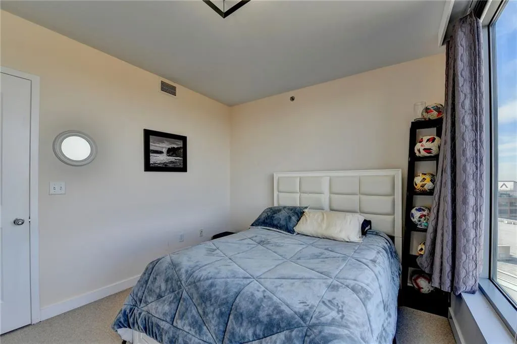 Carpeted bedroom featuring multiple windows