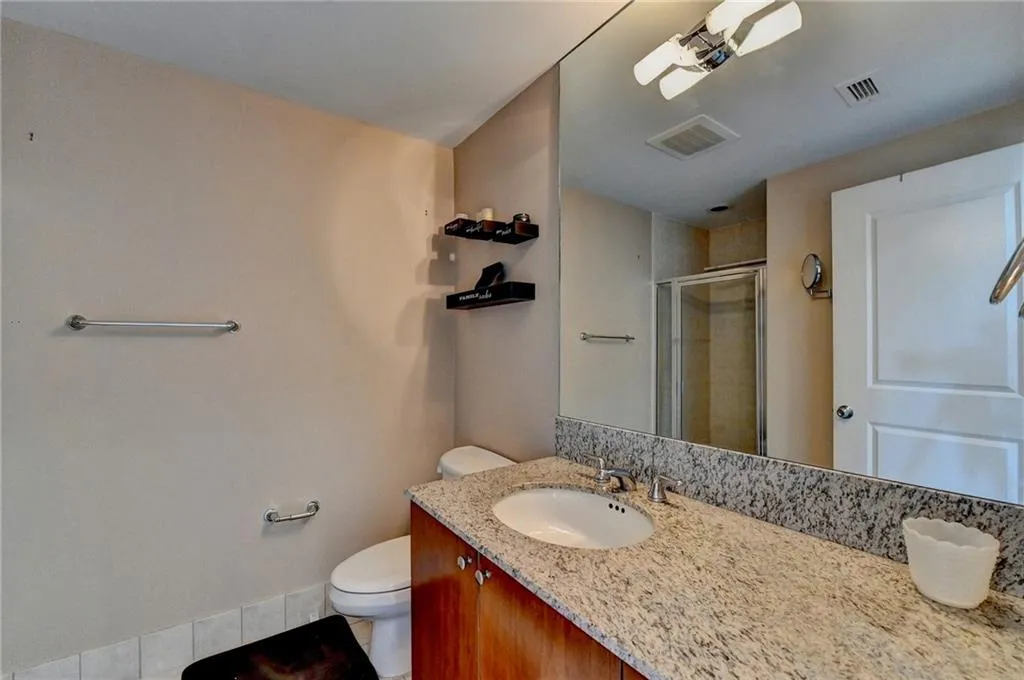 Bathroom featuring vanity, toilet, and walk in shower