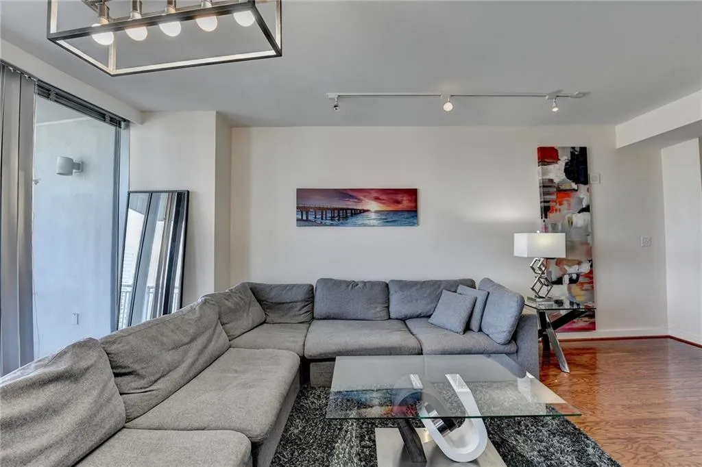 Living room with wood-type flooring and track lighting