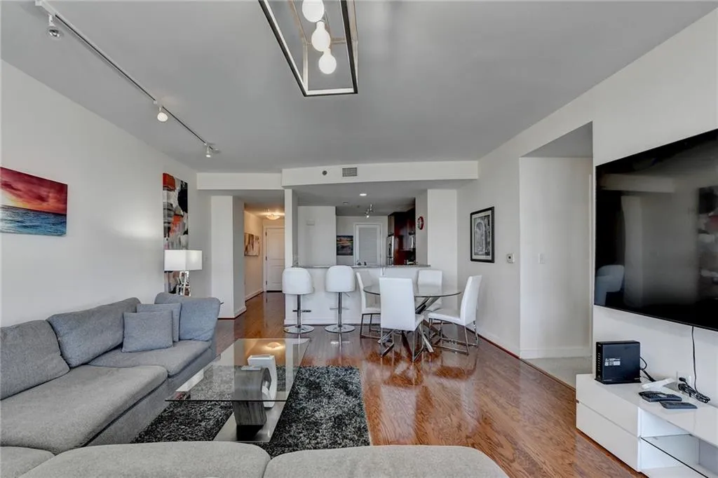 Living room with hardwood / wood-style flooring and track lighting