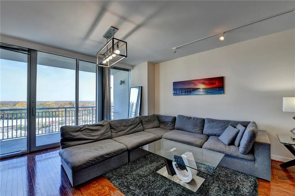 Living room featuring hardwood / wood-style floors, track lighting, and a wall of windows