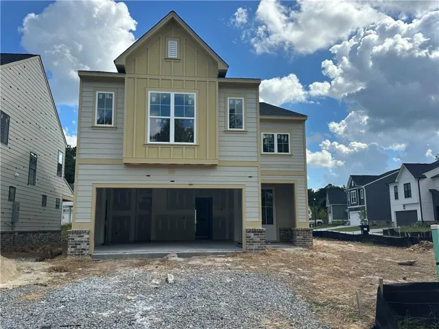 Two-story siding exterior with brick accents, prominent gabled roofline, and attached two-car garage