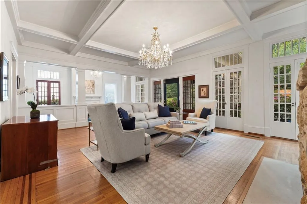 Sunroom featuring french doors, beam ceiling, coffered ceiling, and a chandelier