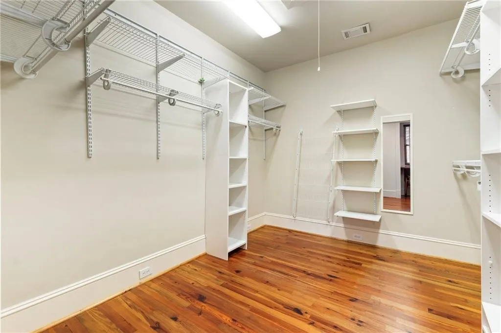 Spacious closet featuring light wood-style floors and attic access