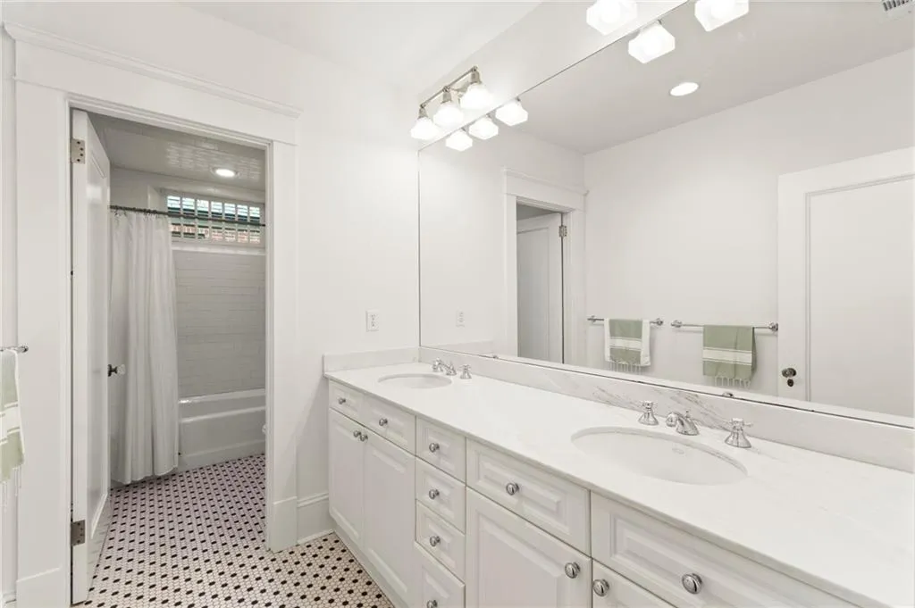 Bathroom with double vanity, shower / tub combo, and recessed lighting