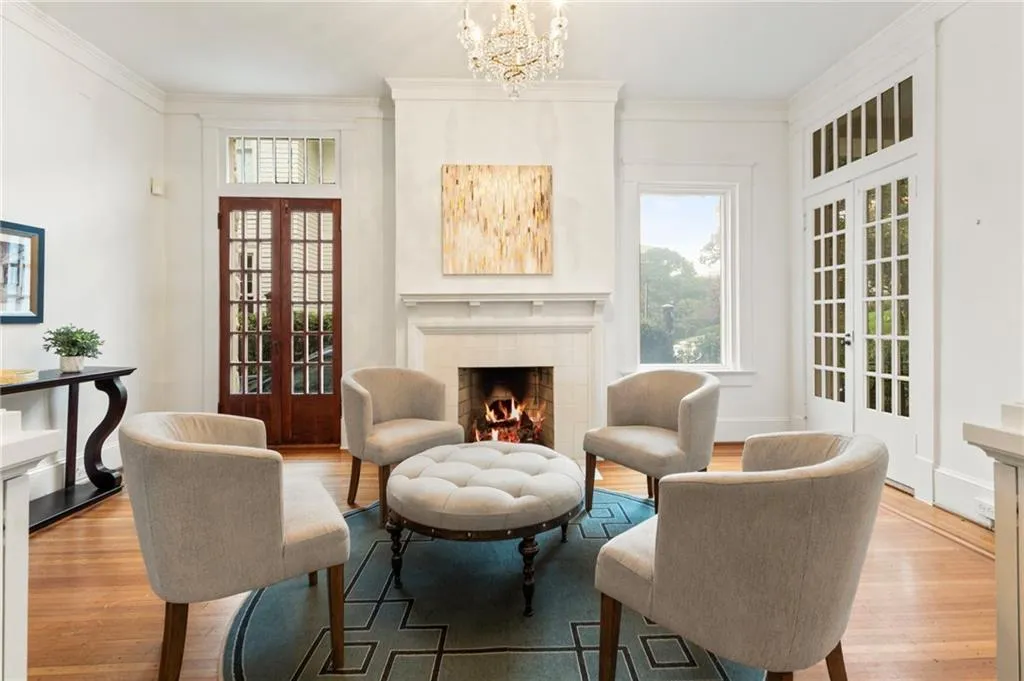 Sitting room with ornamental molding, french doors, a tile fireplace, wood finished floors, and a chandelier