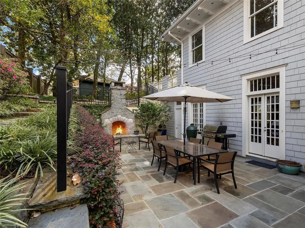 View of patio / terrace with a grill, fence, french doors, an outdoor stone fireplace, and outdoor dining space