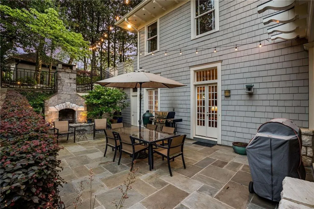 View of patio / terrace with outdoor dining space, an outdoor stone fireplace, area for grilling, and fence