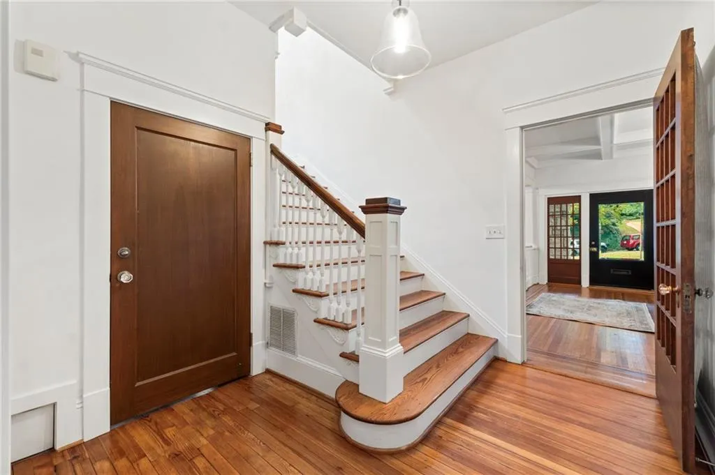 Foyer entrance featuring wood-type flooring, stairs, and beamed ceiling