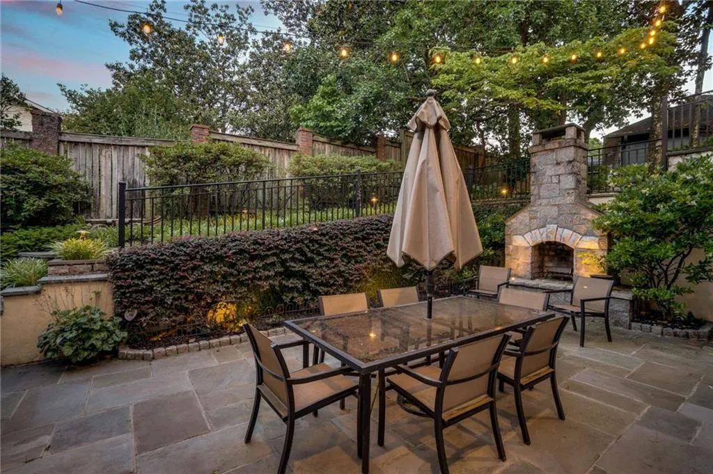 View of patio / terrace with a fenced backyard, an outdoor stone fireplace, and outdoor dining area