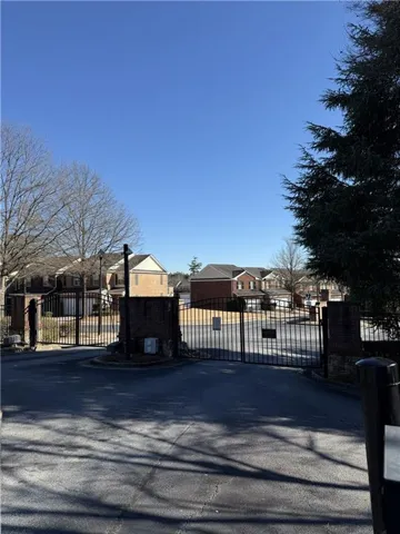 Gated community entrance featuring brick columns and wrought iron gates