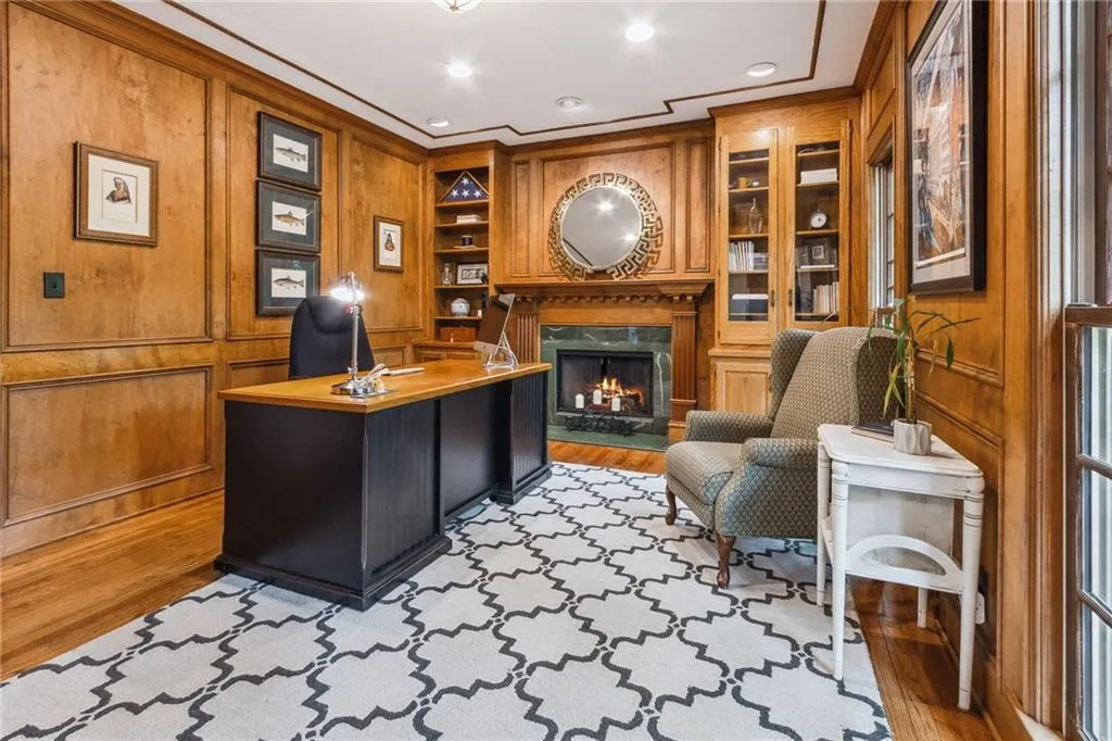 Main floor with rich paneled walls, fireplace, and built in features.