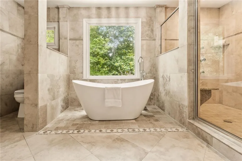 Spa bathroom with luxurious soaking tub, expansive shower and Travertine stone