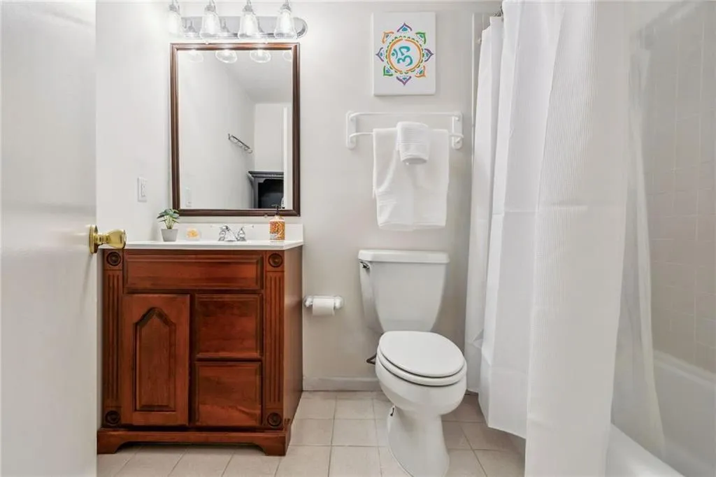 Terrace level Full bathroom featuring tile flooring, vanity, and shower / tub combo