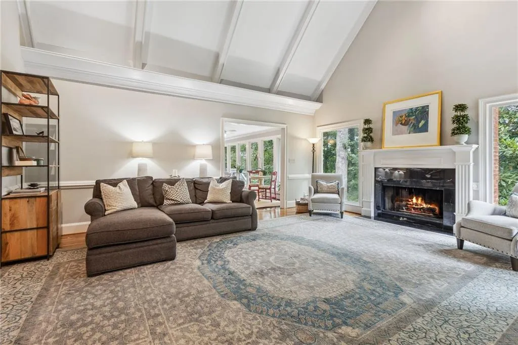 Living room with beamed vaulted ceiling, high vaulted ceiling, and a premium fireplace