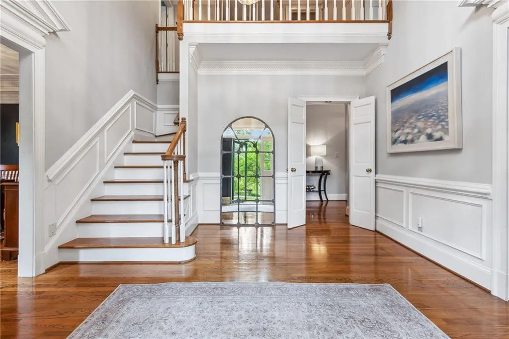 Two story foyer featuring hardwood floors and extensive crown molding