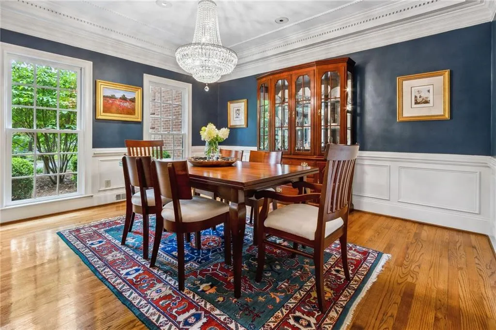Dining area featuring crystal chandelier and wainscoting.