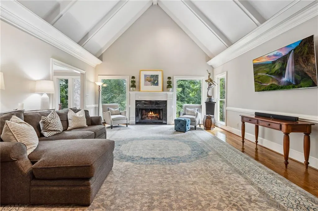 Living room featuring high vaulted ceiling, plenty of natural light, hardwood / wood-style flooring, and a high end fireplace