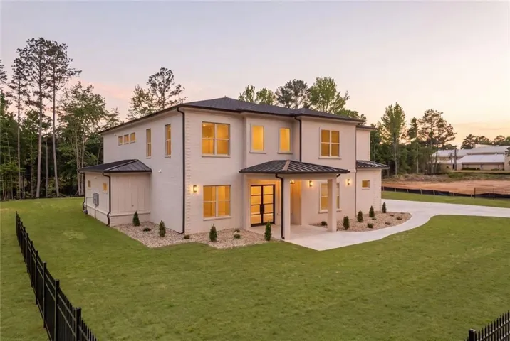 Contemporary two-story residence featuring a light-colored brick exterior and a dark roof