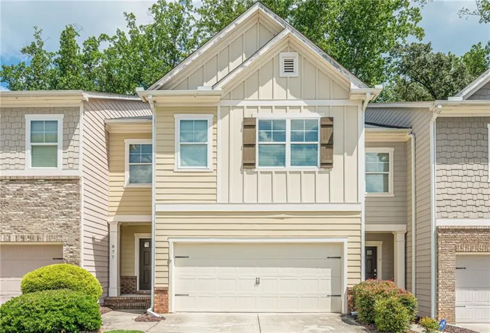 Multi-level townhouse exterior featuring a prominent gable, board and batten siding, horizontal siding, and a single-car garage