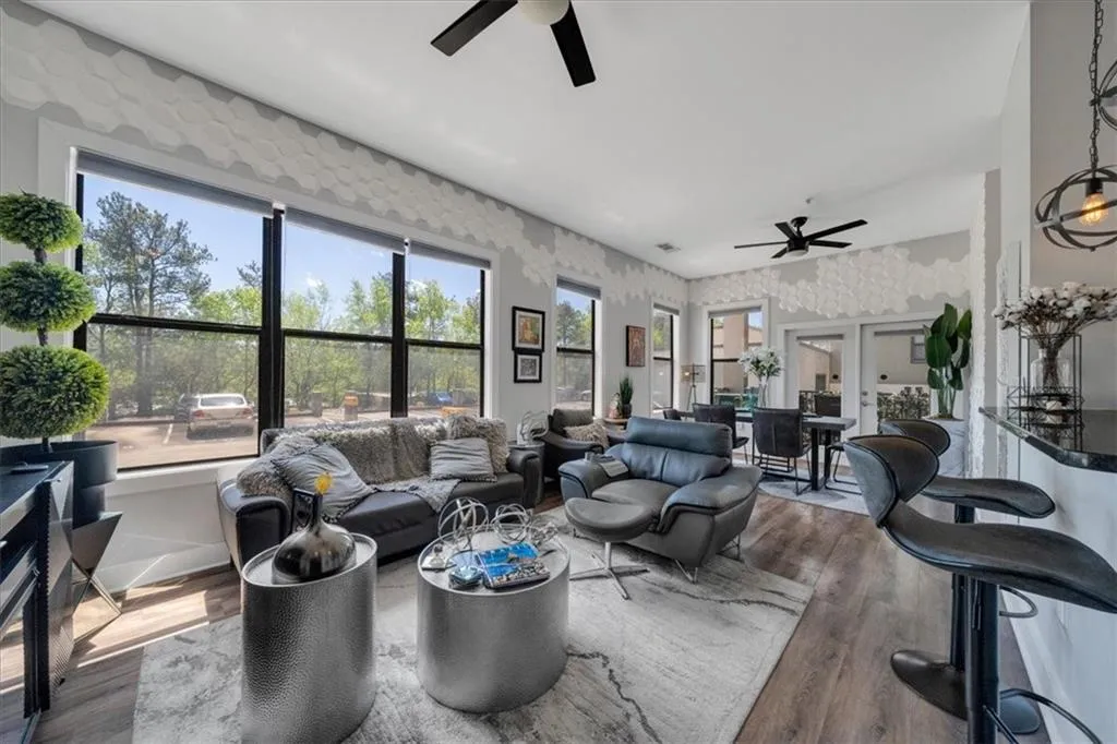 Living room with ceiling fan, dark hardwood / wood-style floors, and french doors
