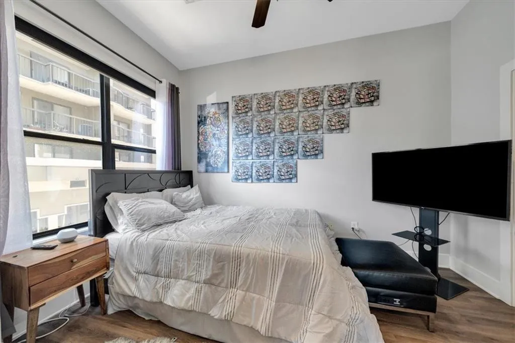 Guest Bedroom featuring hardwood style flooring, window with plenty of light and has a ceiling fan.