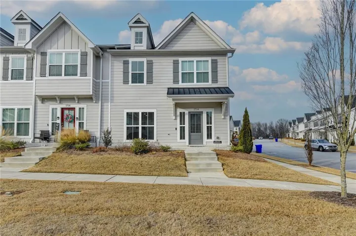 Modern two-story colonial featuring clean-lined architectural details, including peaked rooflines with gabled dormers and decorative trim work