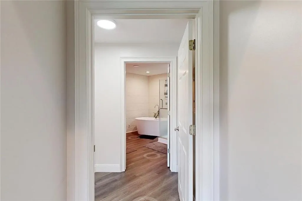 Corridor with light wood-type flooring and baseboards
