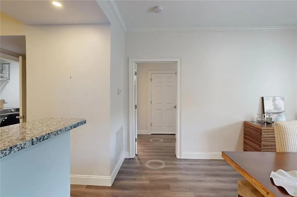 Hallway featuring washer / clothes dryer, wood finished floors, ornamental molding, and recessed lighting