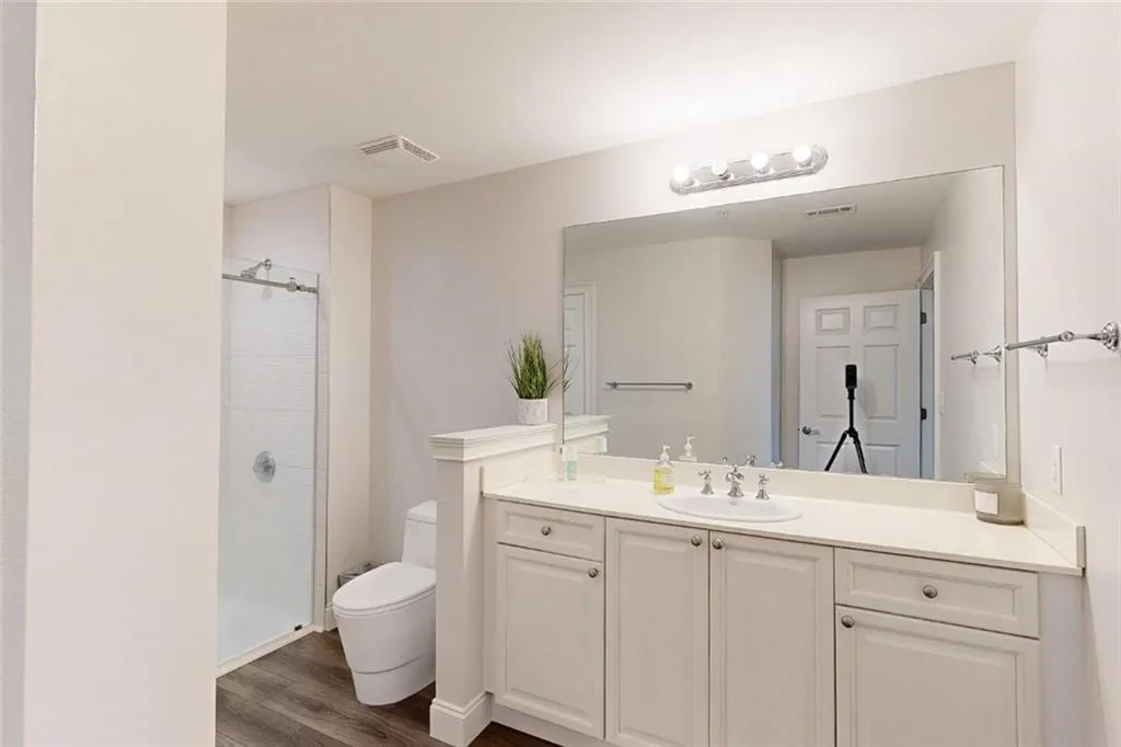 Full bath featuring vanity, a stall shower, and wood finished floors