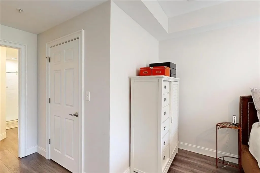 Bedroom featuring dark wood-type flooring and baseboards