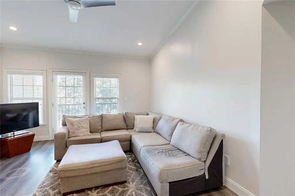 Living room featuring crown molding, wood finished floors, recessed lighting, and a ceiling fan