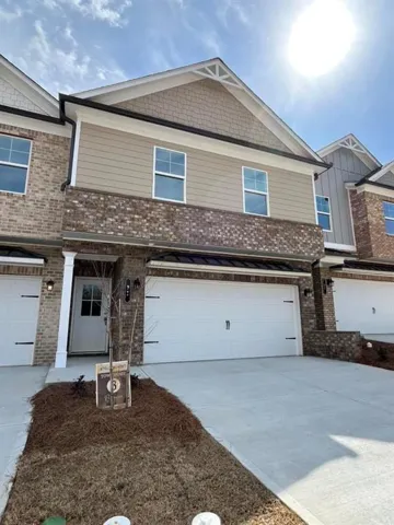 Multi unit property with brick siding, driveway, and a garage