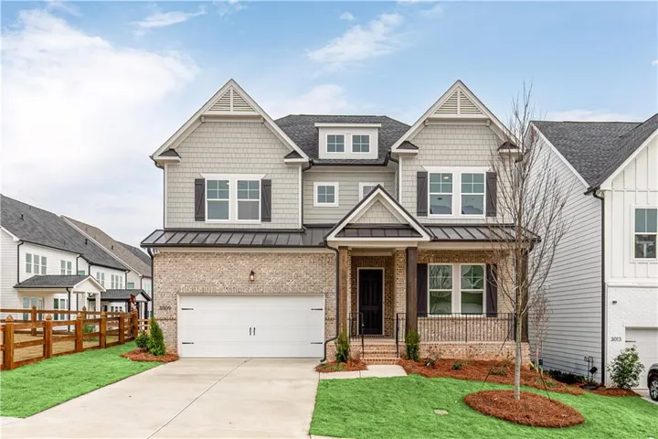 Craftsman-style home with a standing seam roof, a garage, a porch, a metal roof, and driveway