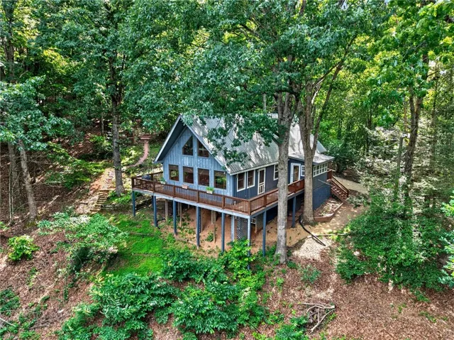 A-frame style residence featuring a prominent front deck, multi-level design, and a metal roof