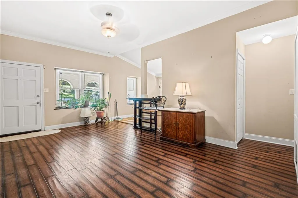 Entryway featuring crown molding, dark wood-type flooring, and a ceiling fan