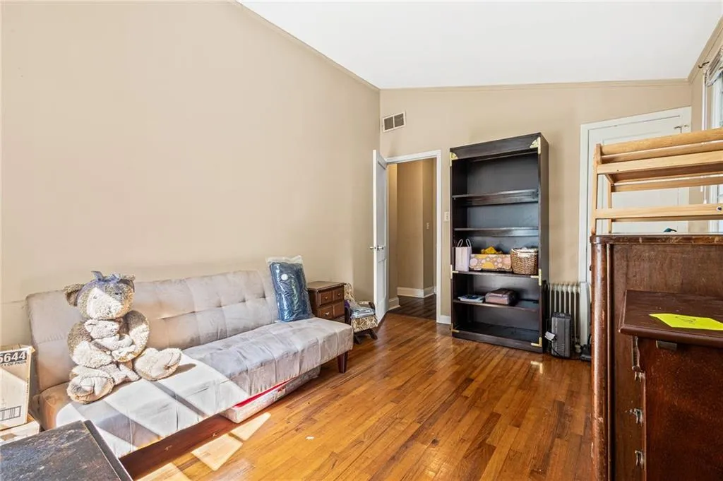 Sitting room featuring lofted ceiling, hardwood / wood-style flooring, and radiator